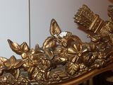 a gold mirror with a bunch of flowers on it