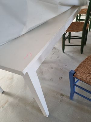 une table blanche avec une chaise bleue devant
