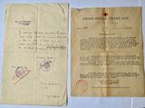 an old document with a red cross on it next to a piece of paper with a red cross on it