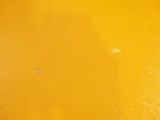 a close up of a bathroom with a toilet and a yellow wall