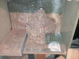 un vase en osier posé sur une table dans un coin de la pièce