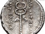 a close up of a silver coin with a key on it