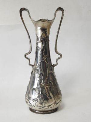 an antique silver plated vase on a white surface with a white background
