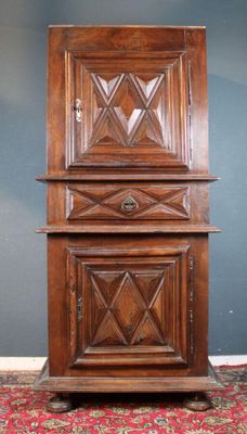 une vieille armoire en bois posée sur un tapis rouge