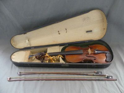 un violon posé dans son étui sur un lit