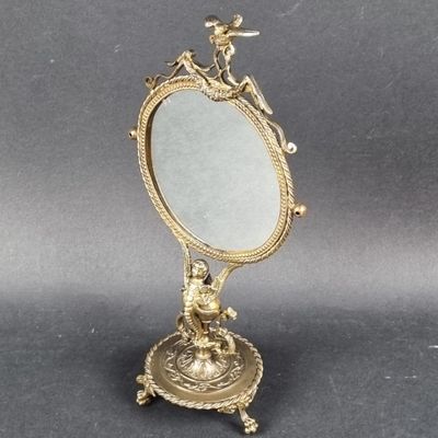 a small mirror with a bird on it on a stand