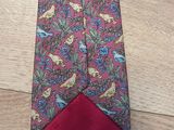 a close up of a neck tie with a bird design on it