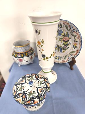 une table bleue sur laquelle se trouvent un vase, une assiette et un bol