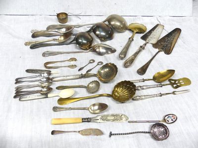a lot of silver spoons and spoon knives on a table