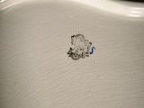 a close up of a white toilet with a blue line on it