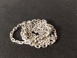 a close up of a silver chain on a black surface