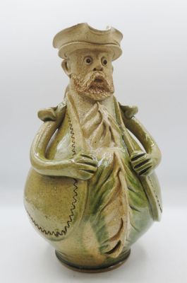 une figurine en céramique représentant un homme portant un chapeau et une barbe