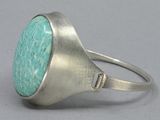 a close up of a silver ring with a turquoise stone in it