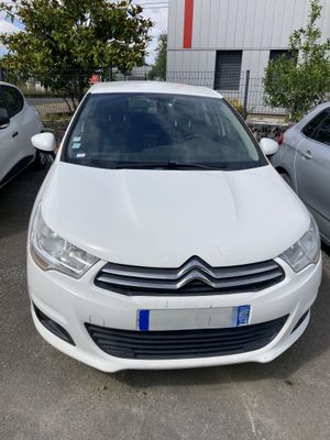 une voiture blanche garée dans un parking à côté d'autres voitures