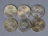 six pièces de monnaie différentes en livres sterling sont disposées en rangée sur une table