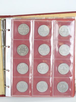 un classeur rouge contenant un tas de pièces de monnaie