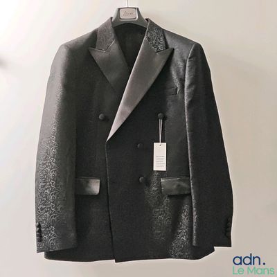 a suit hanging on a hanger on a wall