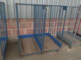 trois cages en acier bleu sont alignées contre un mur de briques