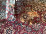 a cat that is sitting on a rug on the floor