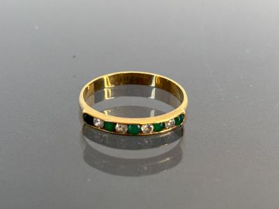 an image of a gold ring with emeralds and diamonds