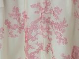 a pink and white shower curtain with a bird on it