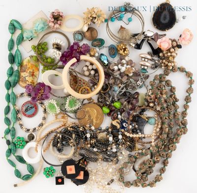 une photo montrant un tas de bijoux variés posés sur une surface blanche