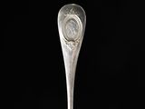 a silver spoon with a coin on it sitting on a table