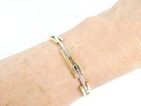 someone is wearing a gold and silver bracelet on their arm