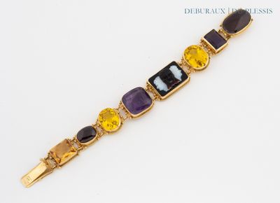 a close up of a bracelet with different colored stones on it