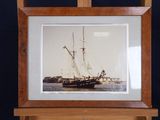 a picture of a ship that is on display in a wooden frame