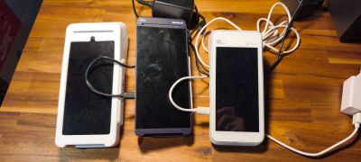 trois téléphones portables posés les uns à côté des autres sur une table