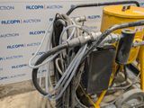 a machine that is sitting on the ground next to a yellow bucket