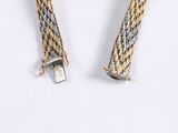 pair of silver and gold toned metal bracelets on a white surface