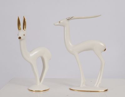 pair of white and gold deer figurines on a white table
