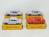 three toy cars are sitting in a box on a white surface