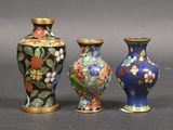 three vases are sitting on a table with a gray background