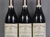 trois bouteilles de vin rouge sont alignées sur une table