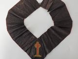 an old collar with a cross on it on a white surface