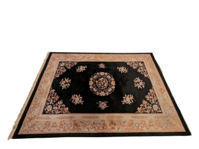 black area rug with a floral design on a white background