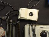 a white camera and some wires on a black table