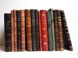 plusieurs vieux livres sont empilés sur une étagère