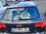 cars parked in a parking lot with a cloudy sky reflected in the rear window
