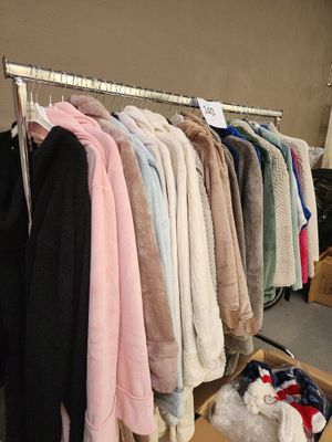 beaucoup de vêtements suspendus à une étagère dans une pièce
