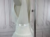 a white dress on a mannequin stand in a room