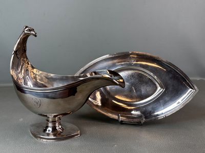 an antique silver plate with a peacock on it next to a silver plate