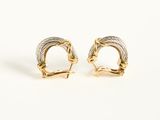 a pair of gold and silver earrings on a white background