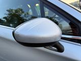 a side view mirror of a car with a reflection of a tree in the window
