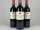 trois bouteilles de vin rouge posées côte à côte sur une table