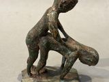 bronze figurine of a boy holding a baby in his arms