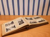 an open book on a wooden table with pictures on it
